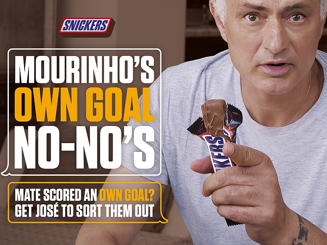 Jose Mourinho holding a SNICKERS in the brand's latest AI-powered campaign