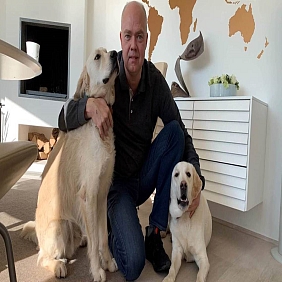 President of Mars Petcare Poul Weihrauch kneels beside his two dogs at his home. 